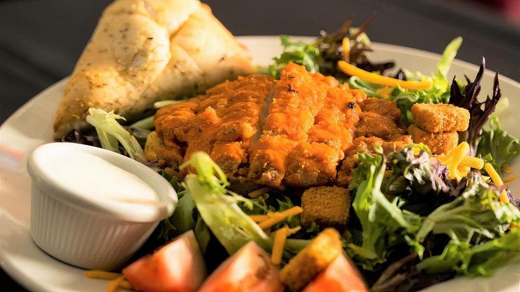 Buffalo Chicken Salad · Fresh iceberg & romaine lettuce with  tomatoes and red onion topped with croutons, cheddar and crispy breaded chicken smothered in buffalo sauce.