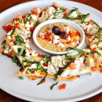 Chicken Piadini · Roasted chicken, bell peppers, feta, house-made fava bean hummus, red chili oil