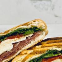 Prosciutto, Mozzarella & Arugula Panini · Sliced prosciutto and mozzarella cheese topped with arugula and roasted red peppers with hou...