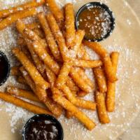Funnel Fries · Crispy funnel cake fries with powdered sugar and served with chocolate, raspberry, and caram...