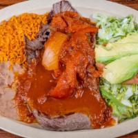 Bistec Ranchero / Ranchero Steak · Carne en salsa roja servida con ensalada, arroz y frijoles. / Delicious steak topped with ou...