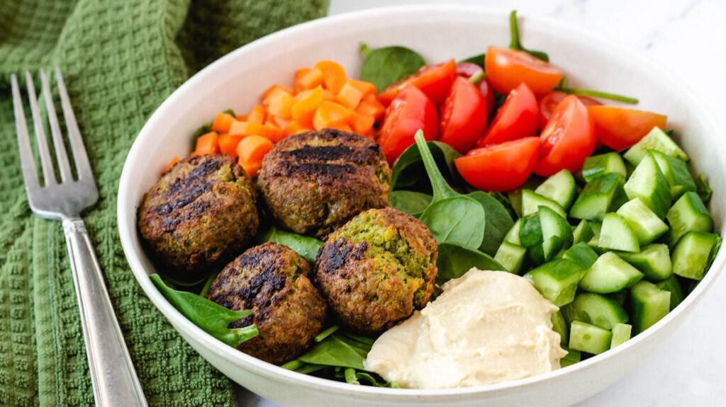 Falafel Plate · Vegetarian. Chickpeas, fava beans, onions, garlic, parsley, and cilantro fried in a bull-shaped patty, on a bed of basmati rice with lettuce, tomatoes, cucumber, signature white sauce, and hot sauce.