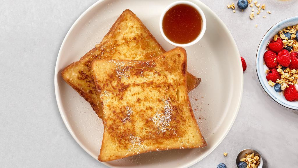 Timeless French Toast · Fresh bread battered in egg, milk, and cinnamon cooked until spongy and golden brown. Topped with powdered sugar, and syrup.