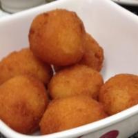 Nuegados Con Chilate · Deep fried cassava bites served with sugar cane syrup and corn flour and ginger porridge.