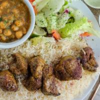 Lamb Kabob · Chunks of boneless lamb shank grilled on a skewer  served on rice with sides of chickpeas, s...