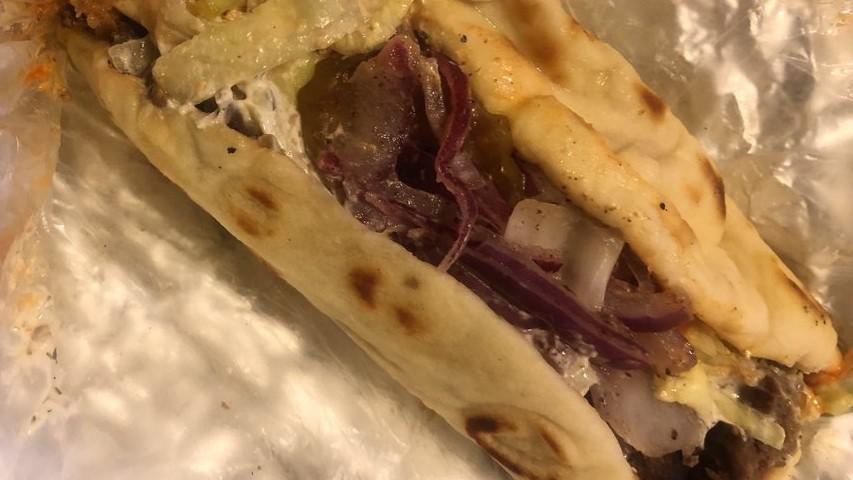 Lamb & Falafel Wrap · Lamb and falafel, on pita bread, side salad, pickles, red onion, hummus, tahini, tzatziki, and hot sauce.