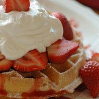 Strawberry Waffle · Golden brown waffle topped with powdered sugar, fresh sliced strawberries, and real whipped ...