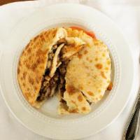 Chicken Shawarma · Thinly sliced marinated chicken, cooked on slowly revolving rotisserie, stuffed in pita brea...