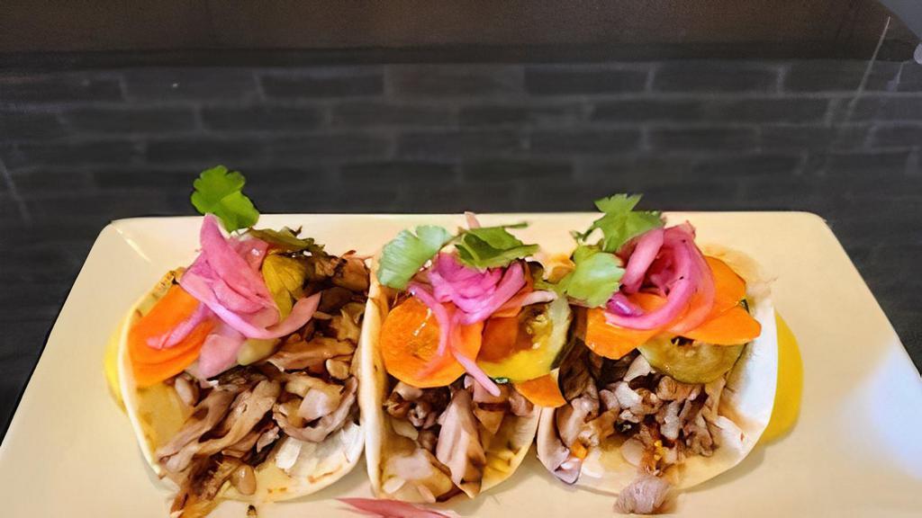 Korean Bbq Pork Tacos · Grilled pork marinated in Gochujang-rice vinegar & soy-ginger.  Served on flour tortillas with cabbage,  spicy cucumbers, carrots & cilantro