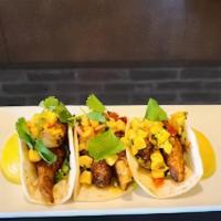 Grilled Fish Tacos · Asian Sea Bass, pan-seared and blackened, served on warm flour tortillas with shredded lettu...