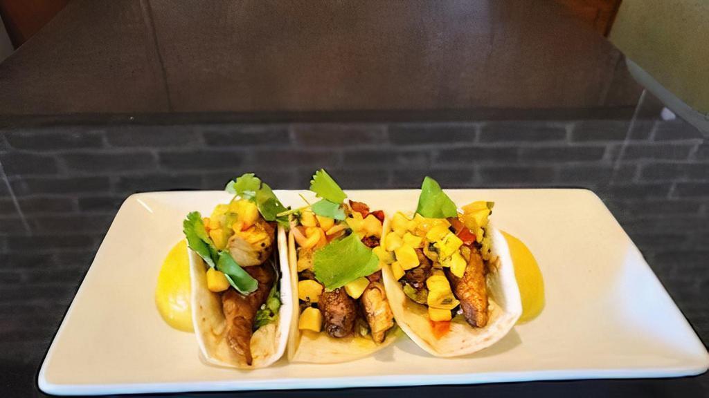 Grilled Fish Tacos · Asian Sea Bass, pan-seared and blackened, served on warm flour tortillas with shredded lettuce and mango salsa