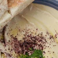 Hummus · Chickpeas pureed with tahini sauce, fresh lemon juice and a hint of olive oil. Served with w...