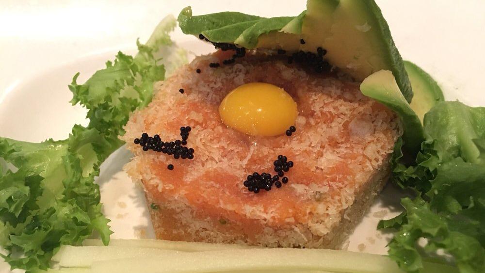 Spicy Tuna Tartar · Spicy tuna topped with tobiko, crunchy and quail egg with sliced avocado and cucumber on the side.