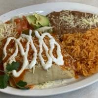 Tamale Platter · Two tamales with ranchero sauce on top, sour-cream, cheese, rice and beans.