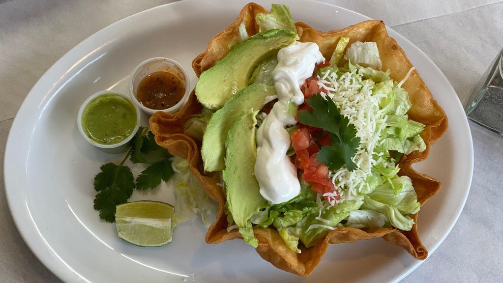 Taco Salad · Rice, beans, choice of meat, lettuce, avocado, tomatoes, sour-cream, cheese, inside a bowl-like fried shell.