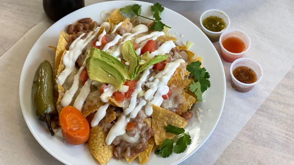 Nachos · Chips layered with re-fried beans, choice of meat and oven melted cheese, topped off with sour cream and avocado.