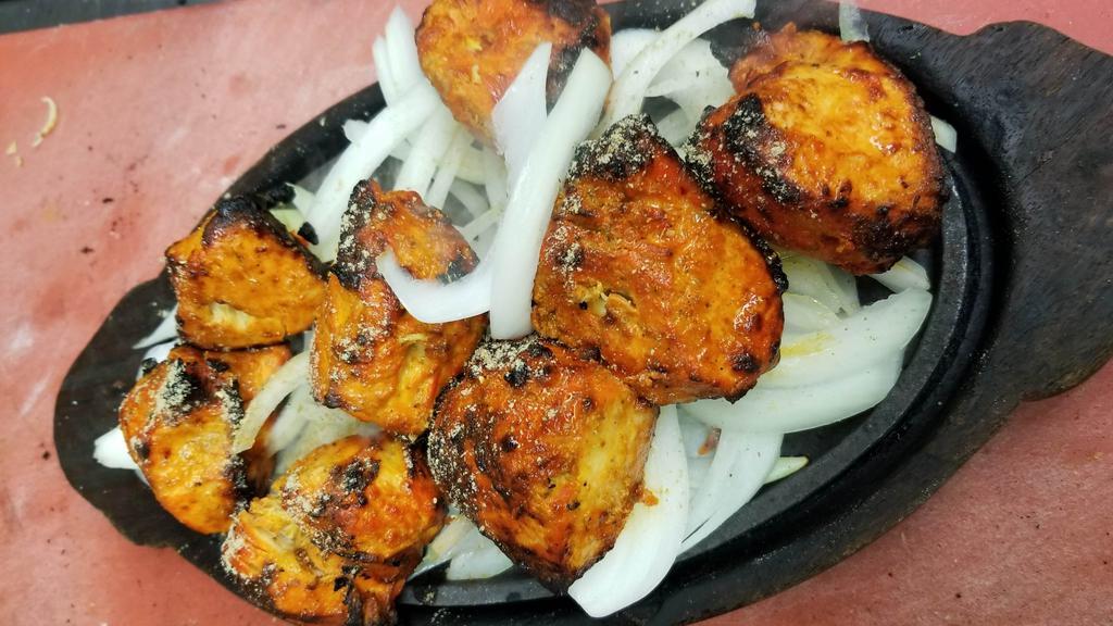 Chicken Tikka Tandoori · Boneless chicken breast marinated with himalayan herbs and spices along with yogurt, then grilled in the tandoor oven and serve sizzling with sautéed onion, bell pepper, cabbage and carrot.