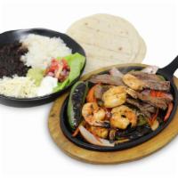 Peruvian Fajitas · Served on a sizzling plate with wok-seared onions, green peppers, tomatoes, white rice, blac...