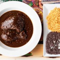 Mole Poblano De Pollo · Traditional chocolate spicy sauce and chicken thighs served with rice and beans.