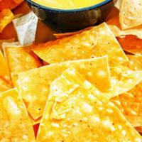 Chips & Queso · Our secret recipe and fan favorite! Queso made with aged cheddar, green chiles, and roma tom...