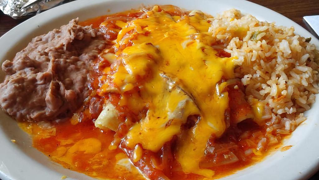 Red Chicken Enchiladas · Two chicken enchiladas topped with our red tomato and onion sauce and cheese, served with rice, beans, and two corn tortillas.