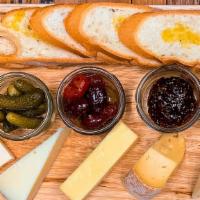 Artisan Cheese Board · Includes: 
- 6 Month Manchego
- French Brie
- Provolone Piccante
- 2 Year New England Chedda...