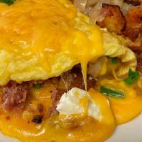 Au Gratin Potato Omelet · Diced potatoes, green onions, and bacon folded in with cream cheese and topped with melted c...