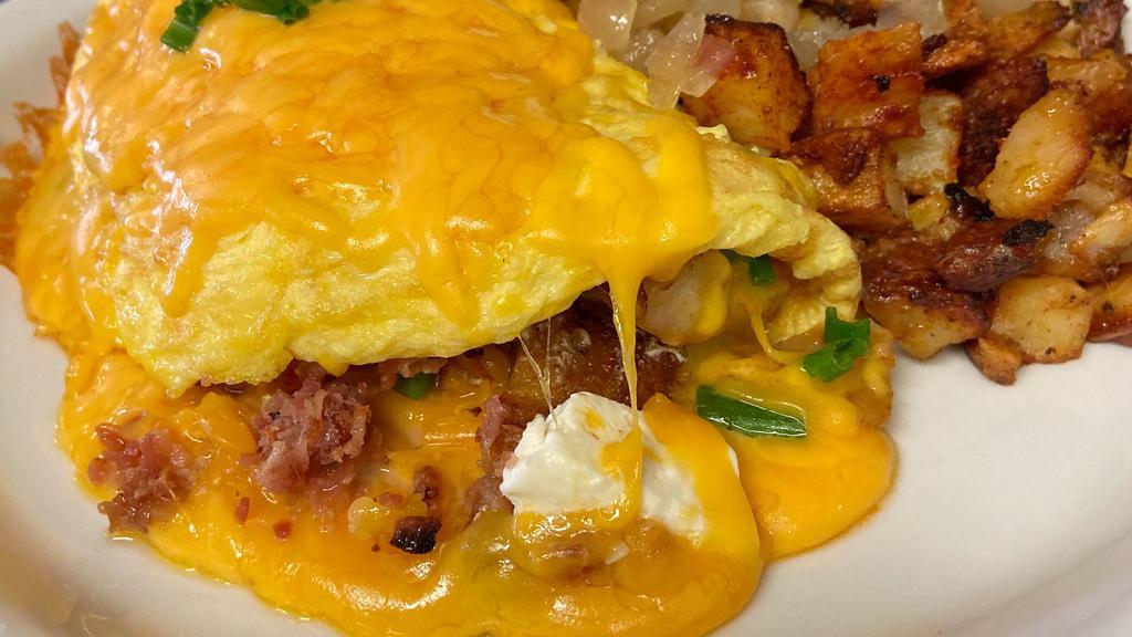 Au Gratin Potato Omelet · Diced potatoes, green onions, and bacon folded in with cream cheese and topped with melted cheddar.