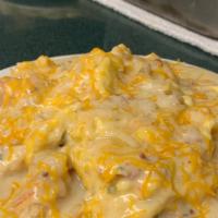 The Country Scramble · Three scrambled eggs over homemade biscuits covered with sausage gravy and topped with chedd...