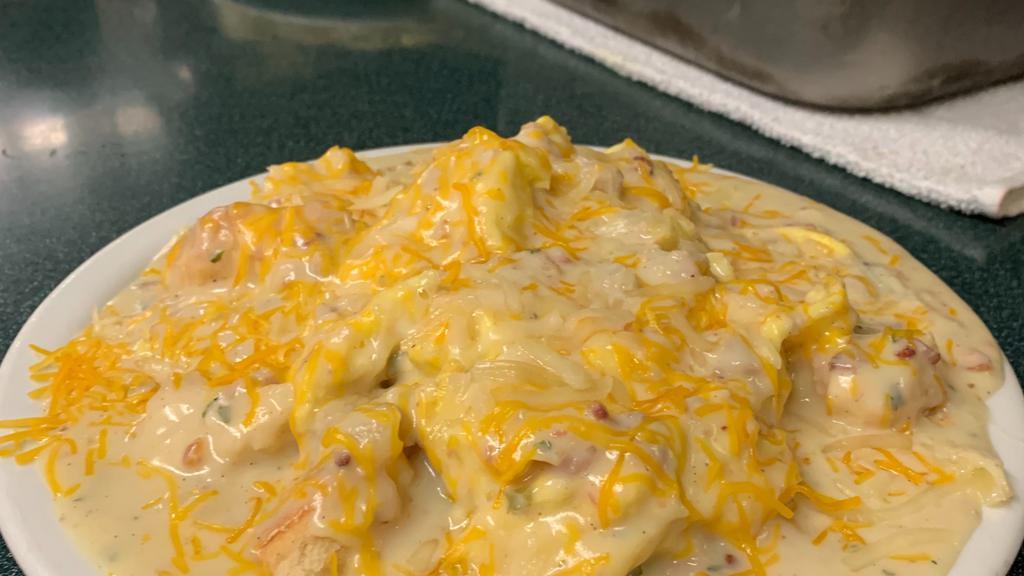 The Country Scramble · Three scrambled eggs over homemade biscuits covered with sausage gravy and topped with cheddar cheese.