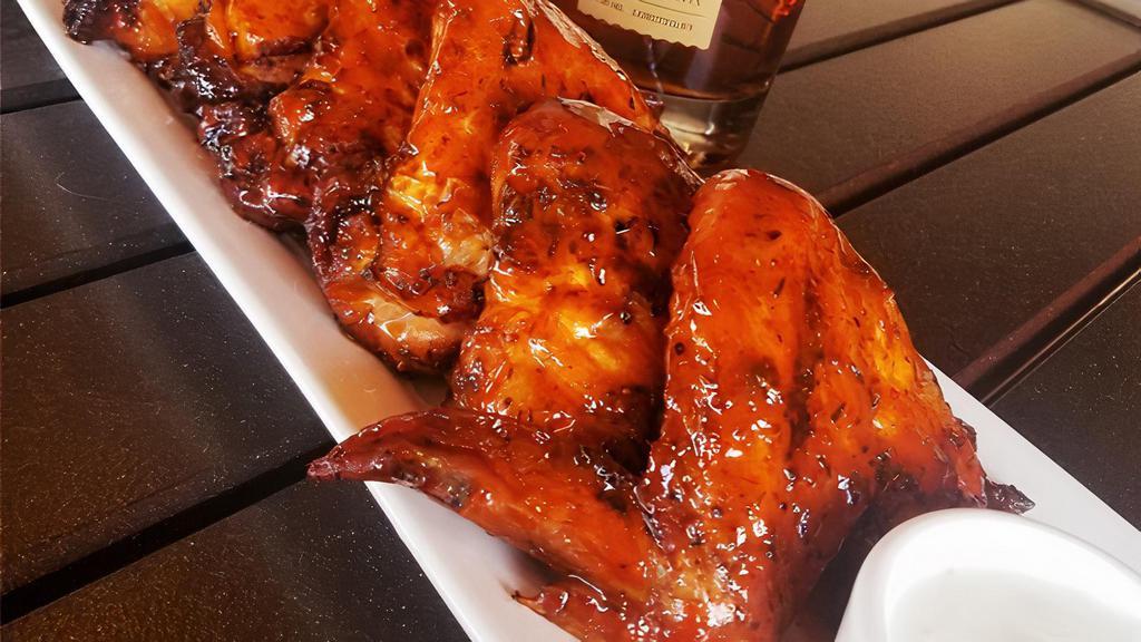 Woodfire Buffalo Wings · six whole wings rubbed with signature herbs and spices, roasted over an open flame and brushed with our honey buffalo sauce, with blue cheese or ranch dressing. GF.