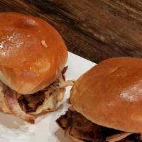 Pulled Pork Sliders · three pork sliders topped with golden barbecue sauce, crispy red onions