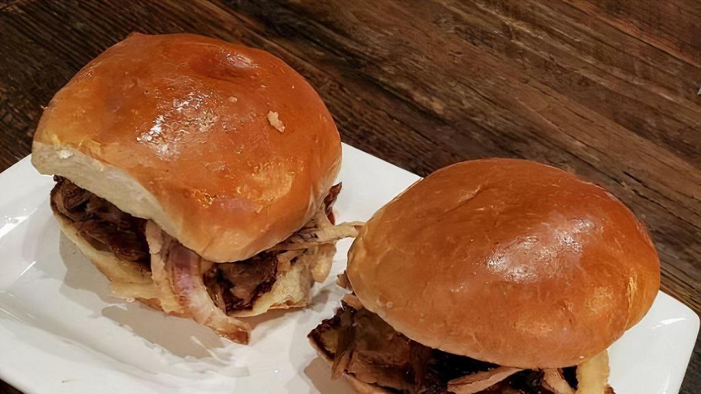 Pulled Pork Sliders · three pork sliders topped with golden barbecue sauce, crispy red onions
