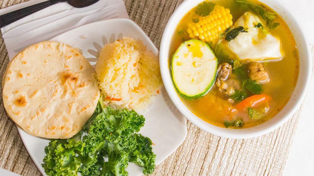 Sopa De Pollo (Chicken Soup) · Bowl of Chicken soup with side of tortillas and rice.