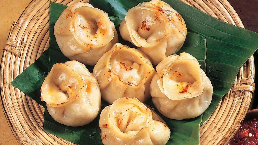 Chicken Momos · (8 pcs) Savory steamed flour dumplings filled with flavorful chicken served with a tomato-based sauce (Nut Free)