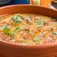 Daal Tarka · Split chickpeas lentils mixed with a blend of savory spices topped with onion, tomato, & spi...