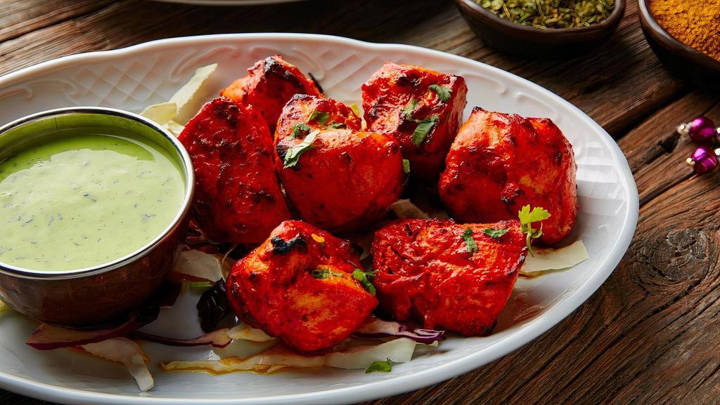 Chicken Tikka · Chunks of boneless chicken marinated in yogurt & Indian spices, then baked on skewers in our tandoor served with a side of cumin rice (Gluten-Free, Nut-Free)