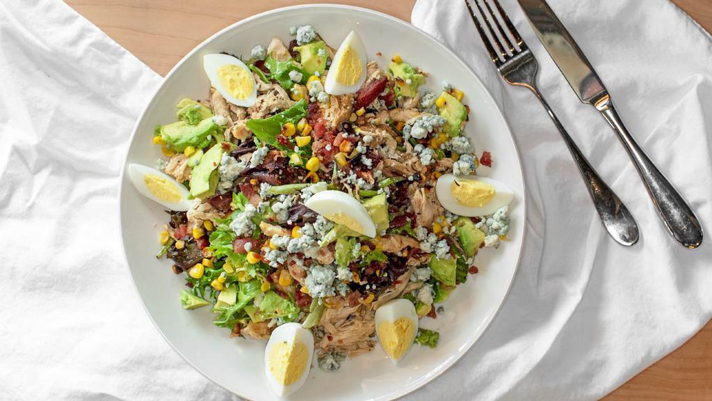 Cobb Salad · Gluten free. Mixed greens, chicken, avocado, roasted corn and egg tossed in a cilantro lime vinaigrette.
Topped with bacon and crumbled Gorgonzola cheese.