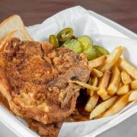 Pork Chops Basket · Two pork chops, bread, fries, pickles, and peppers.
