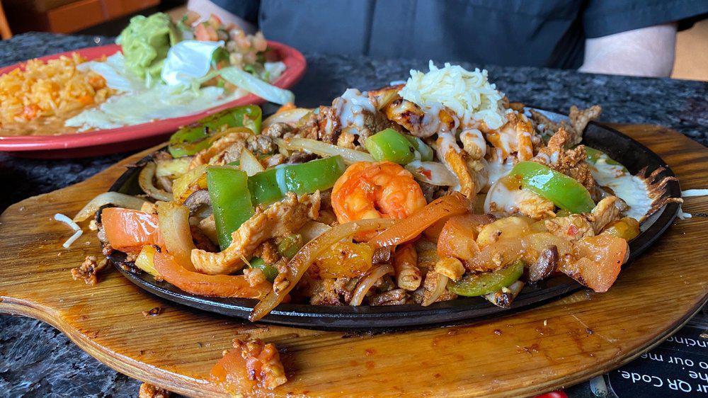 Acapulco Fajitas · Chicken, shrimp, chorizo, and steak cooked with bell peppers, mushrooms, onion, and tomato. Served with lettuce, guacamole, sour cream, pico de gallo, tortillas, rice and beans.