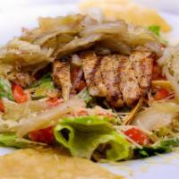 Southwestern Chicken Caesar Salad · Romaine lettuce, grilled chicken, grilled onions, tomatoes and tortilla strips topped with c...