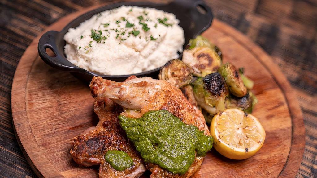 Brick Chicken · Brick Pressed Heritage Farms Chicken over Roasted Fingerling Potatoes & Crispy Brussels Sprouts, topped with Chimichurri Sauce & Hot Honey