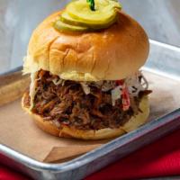 Pulled Pork Sandwhich · Pulled pork shoulder, mixed with Carolina vinegar sauce, topped with coleslaw and served on ...