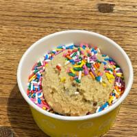 Rainbow Sprinkle Chocolate Chip Cookie Dough · Sprinkle dots chocolate chip cookie dough served with melted chocolate on top.