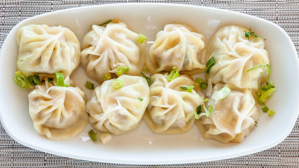 Chicken Momo · Steamed dumplings made with minced chicken, onion, garlic, ginger and spiced mix. Served with tomato achar (Nepalese tomato based sauce).