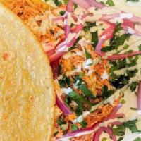 Tinga De Pollo · Pulled chicken cooked in tomato/chipotle sauce , toppings: table cream, cilantro, pickled re...