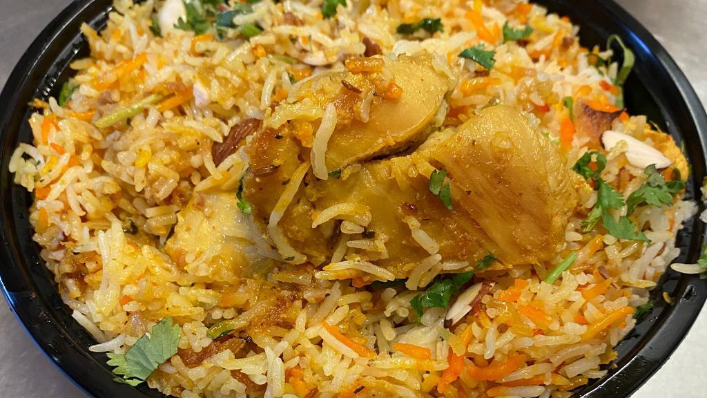 Chicken Biryani · Selected chicken pieces sauteed with basmati rice, vegetables, nuts and raisins; garnished with fresh herbs. Served with raita.