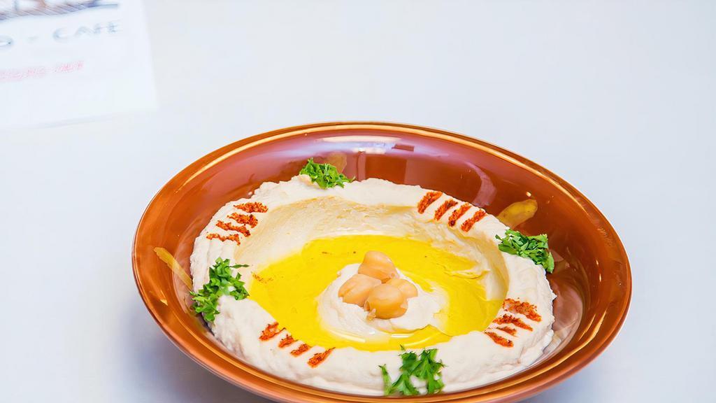 Hummus · Chickpeas dip with sesame seed sauce topped with olive oil.