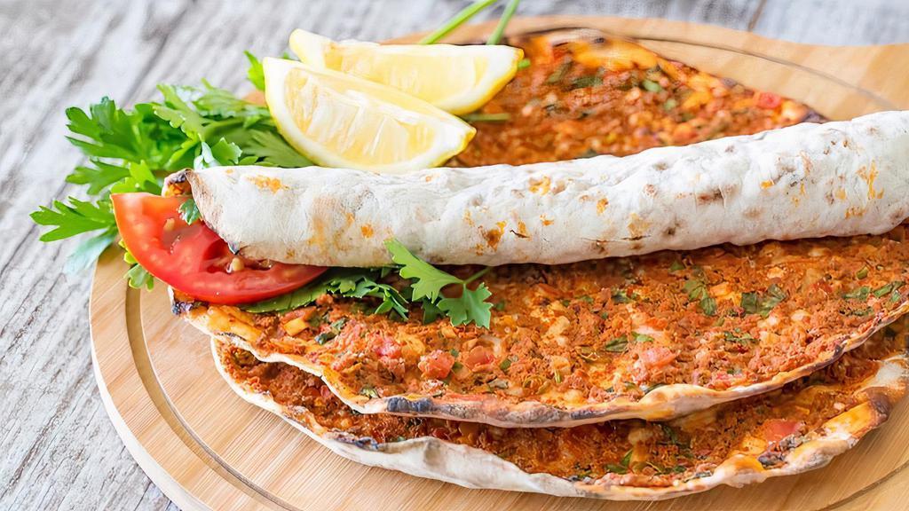 Lahmacun (Meat Pizza) · Turkish Pizza flatbread topped with minced meat, minced vegetables, and herbs including onions, garlic, tomatoes, red peppers, and parsley, flavored with spices such as chili pepper and paprika