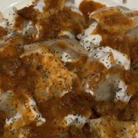 Mantu · Ground beef and scallion-filled dumpling topped with homemade yogurt, meat sauce and mint.